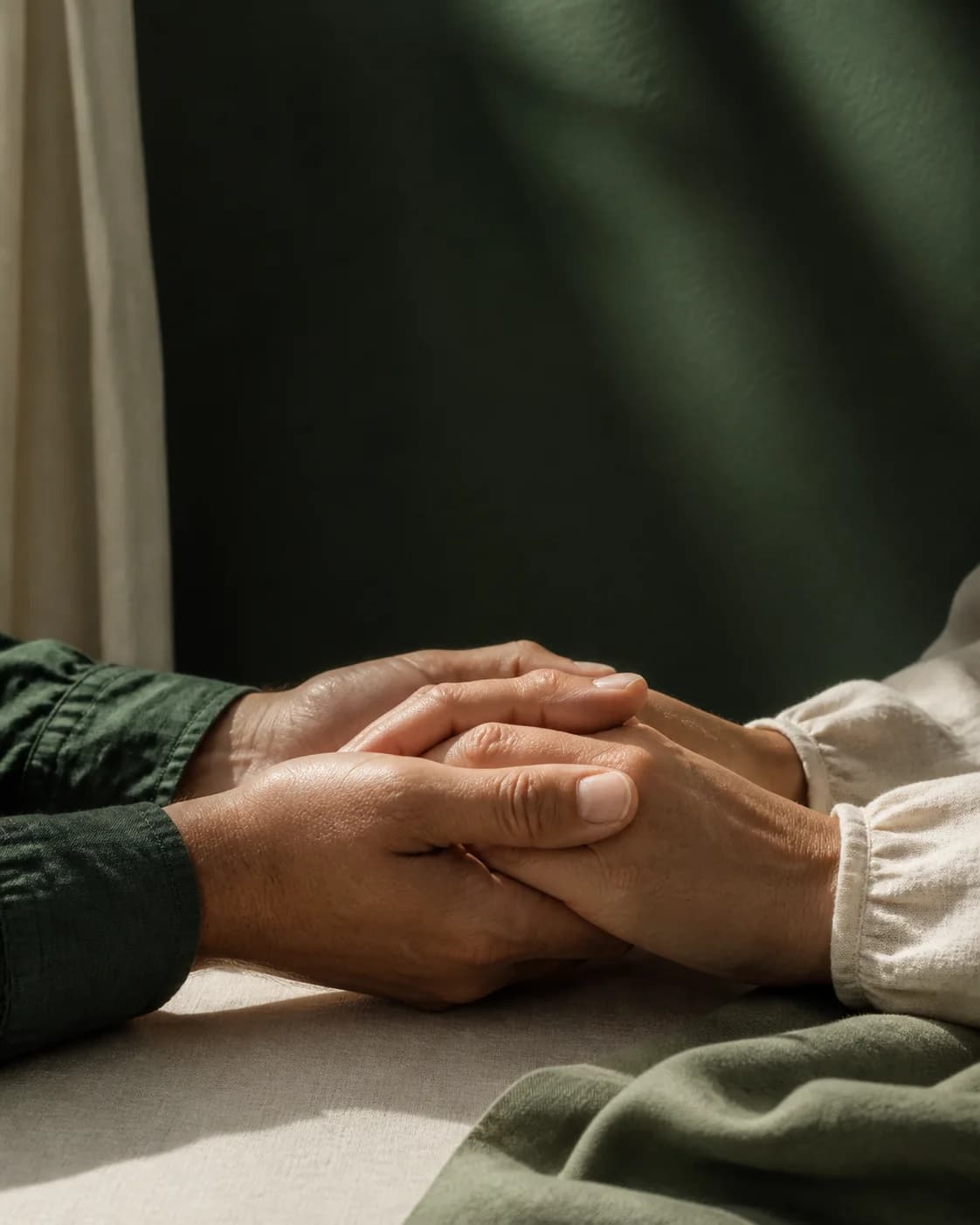 Dos personas se acompañan sosteniendo sus manos en un momento de oración.